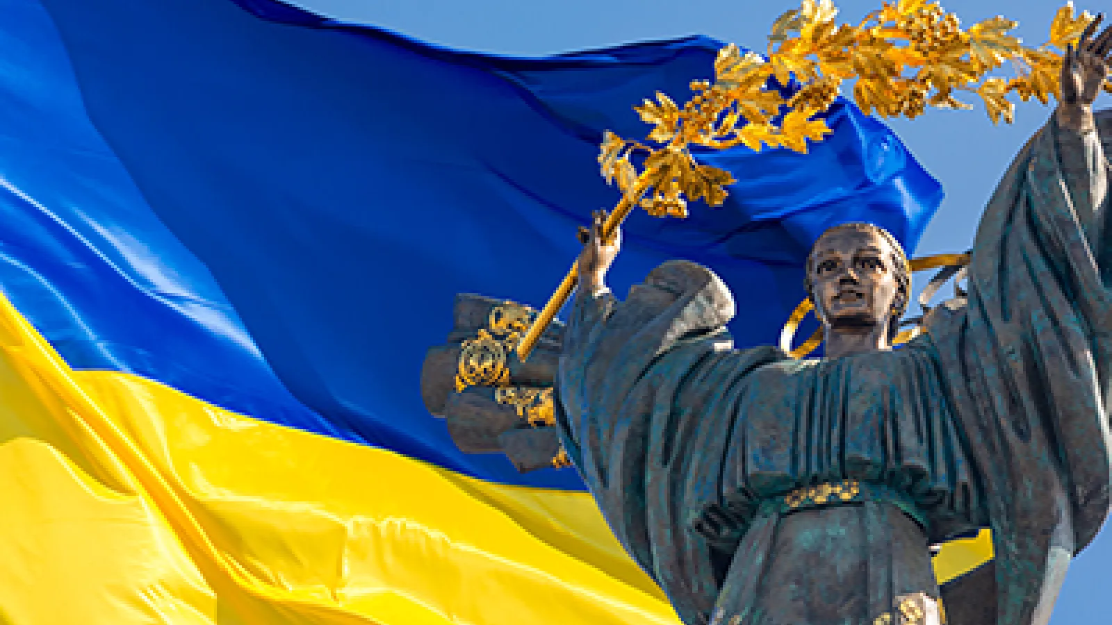 Monument of Independence of Ukraine in front of the Ukrainian flag. 