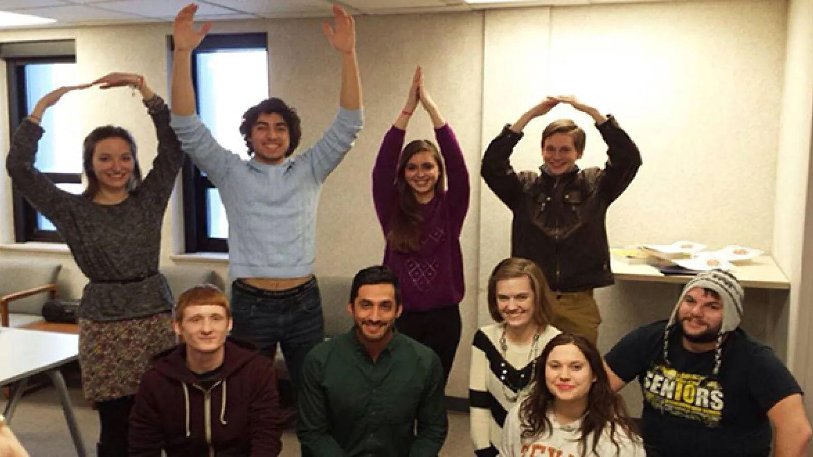 Four students standing in back row making O-H-I-O, five kneeling in front